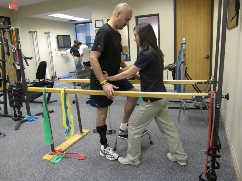 Physical therapist helping patient walk