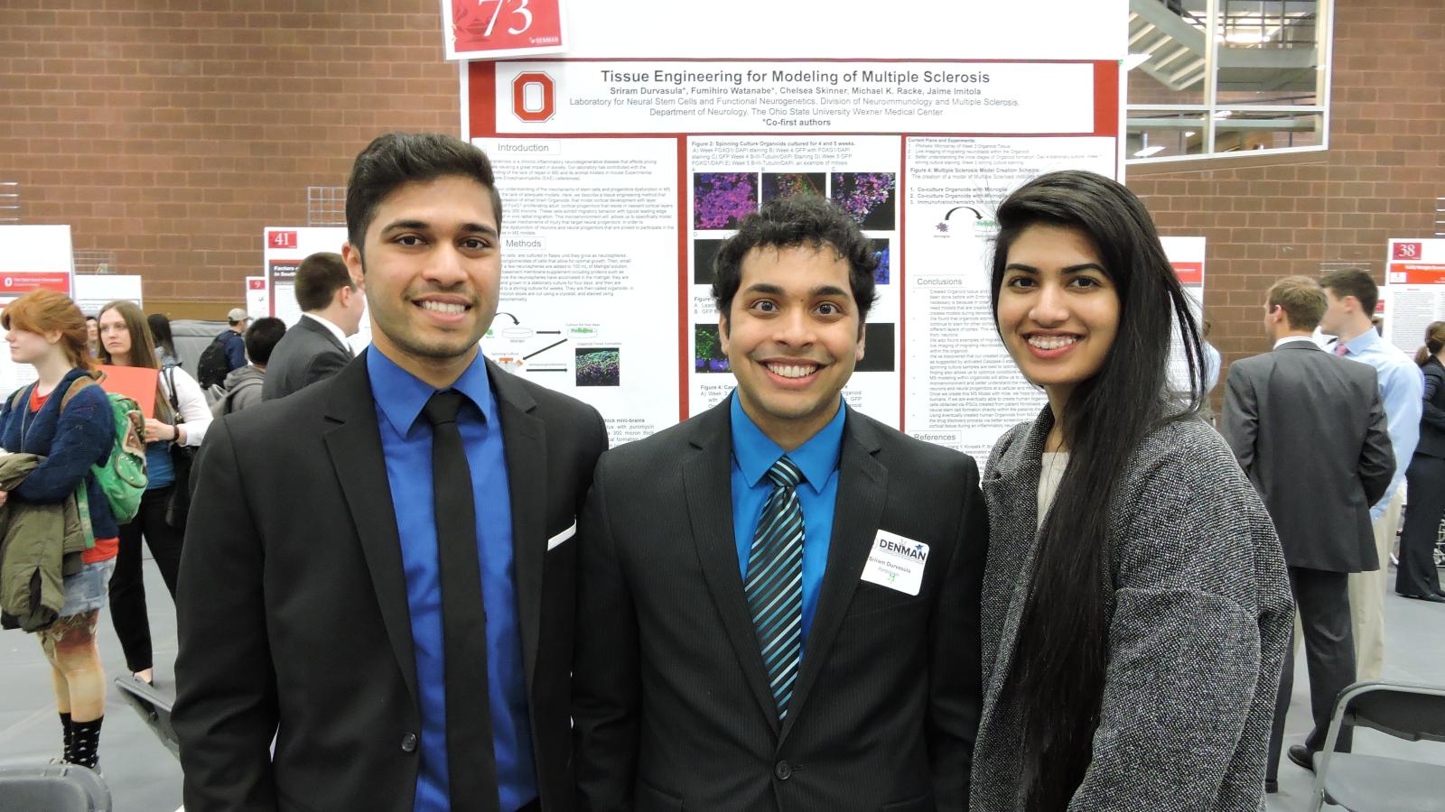 Students in front of research poster at the denman 