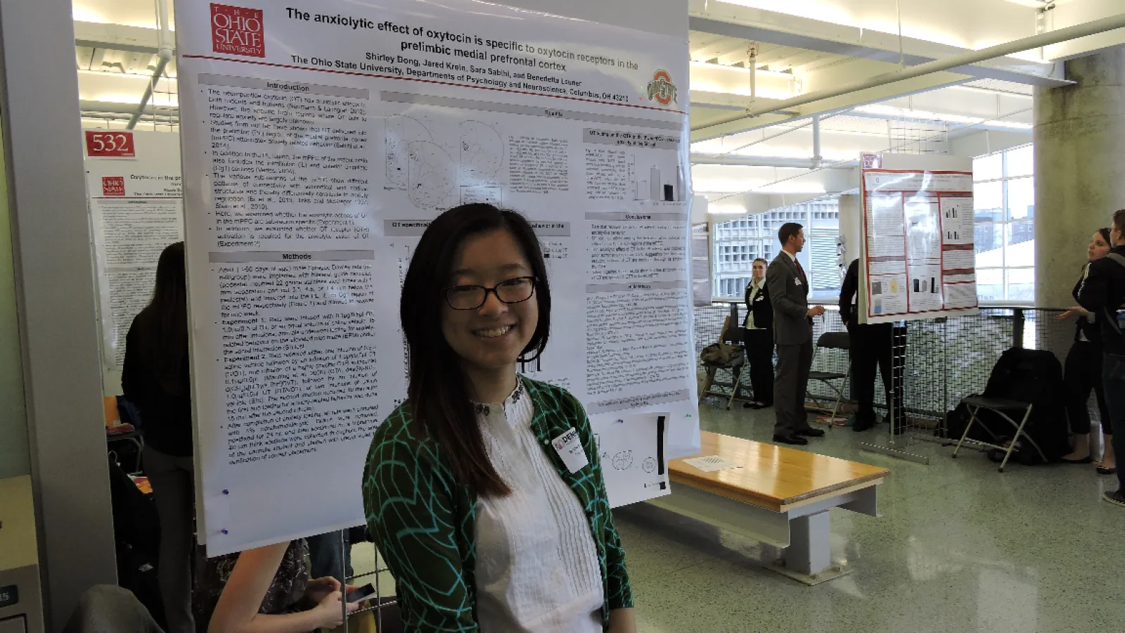 Student with research poster at the denman 