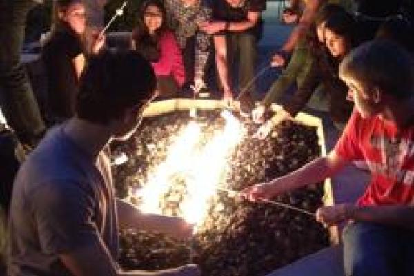 Image of students making smores over a fire