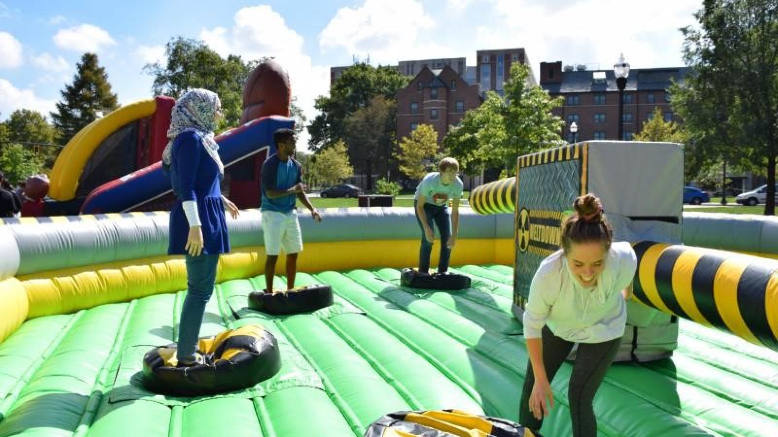 Students playing a game on the inflatable at field day 