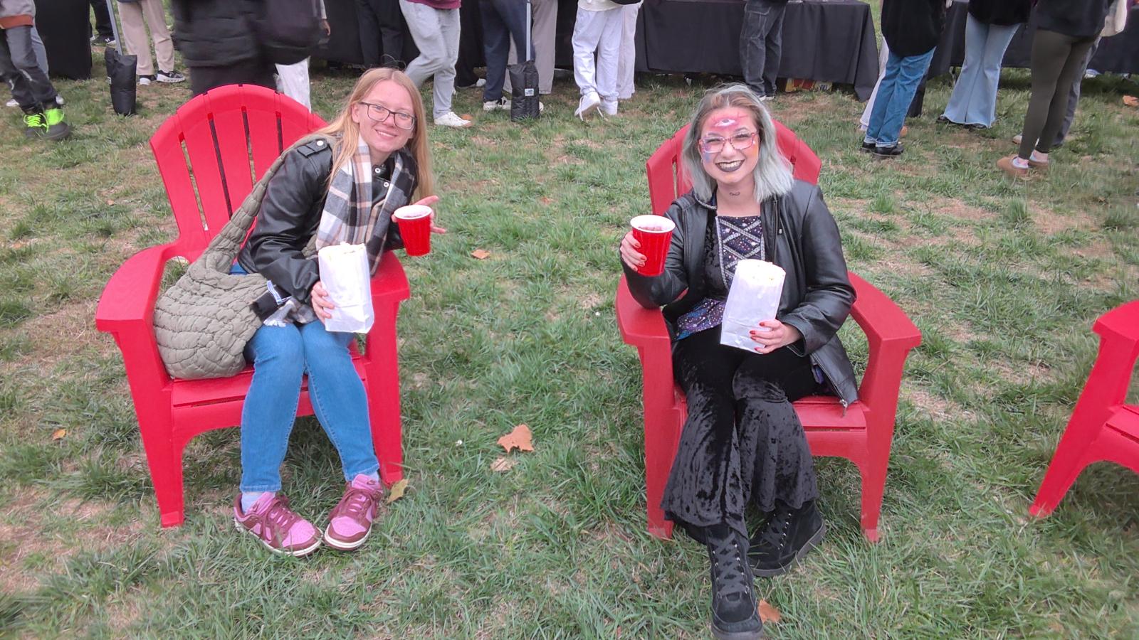 two students sitting on chairs in halloween costumes